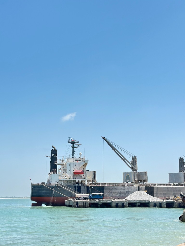 Cargo ship docked at port with crane and berth operations